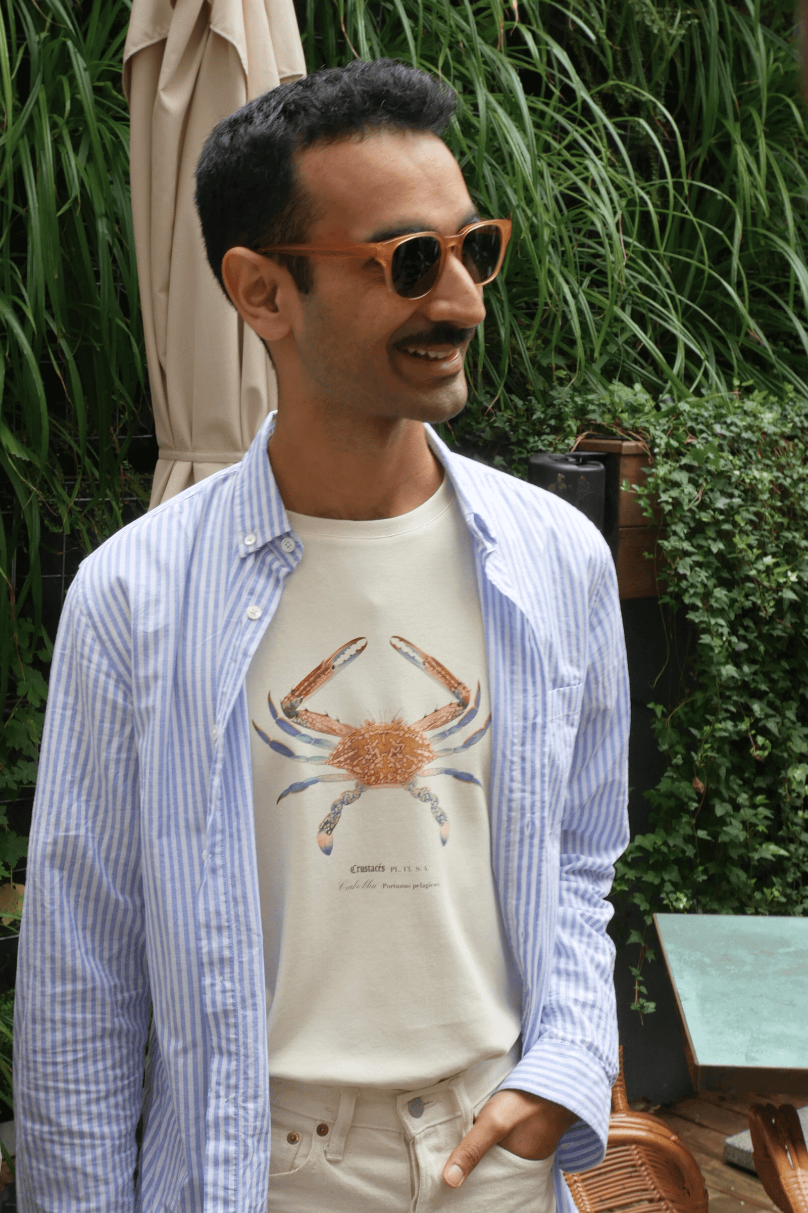 Jérôme porte un T-shirt Fanatura mixte motif Crabe bleu taille M avec une chemise rayée assortie
