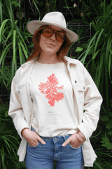 Joséphine porte un T-shirt Fanatura mixte motif Algue Carola taille M avec une veste assortie devant un mur végétal